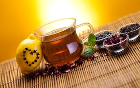 Заваренный чай в чашке на столе с заваркой и лимоном