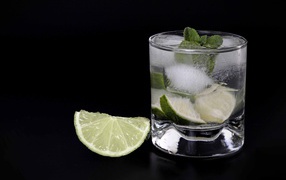 Caipirinha cocktail on a black background with a lime slice