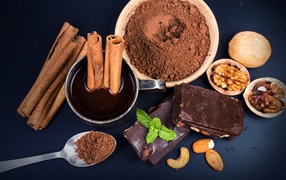 Cocoa with cinnamon, nuts and chocolate on the table