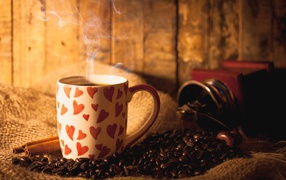 Cup with hot coffee on the table with coffee beans and cinnamon