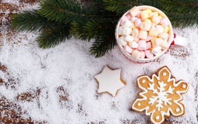 Чашка с маршмеллоу на столе с печеньем и еловой веткой 