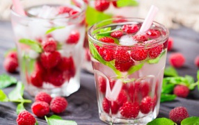 Drink in a glass with raspberries and ice cubes