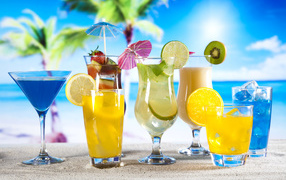 Glasses with tropical cocktails on the sand on the beach