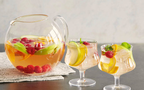 Лимонад в графине на столе с бокалами 