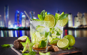 Mojito cocktail with lime and carom on the background of the city