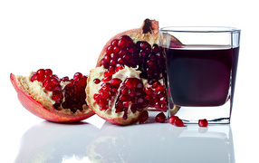 Pomegranate juice with pomegranate fruit on white background