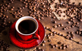 Red coffee cup on a table with coffee beans