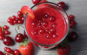 Smoothies in a glass with berries of strawberry, red currant and cherry