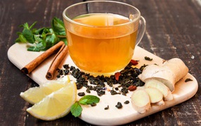Tea with ginger, lemon, cinnamon and mint on a cutting board