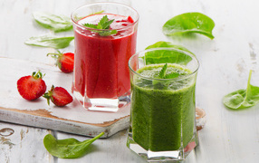Two glass glasses with strawberry smoothies and smoothies with spinach