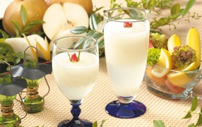 Два бокала сока на столе с фруктами