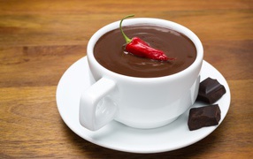 White cup of hot chocolate with red pepper