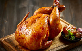 Аппетитная запеченная курица на разделочной доске