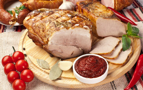 Appetizing ham on the table with sauce and tomatoes