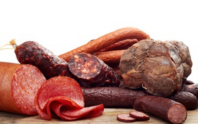 Аппетитная колбаса и мясо на белом фоне