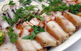 Аппетитное нарезанное копченое сало с зеленью 