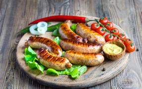BBQ sausages with red pepper and tomatoes on a cutting board