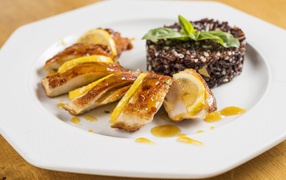 Куриный рулет на белой тарелке с рисом