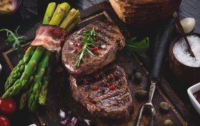 Жареное мясо с зеленой спаржей на столе 