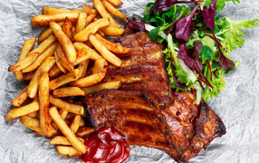 Fried ribs with French fries and salad