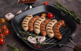 Grilled sausages on a table with vegetables