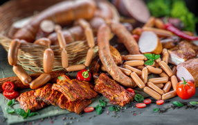 Копченые ребрышки с колбасой на столе 