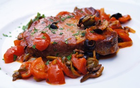 Стейк с овощами на большой белой тарелке