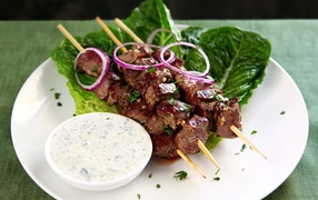 Вкусный шашлык на деревянных шампурах с соусом