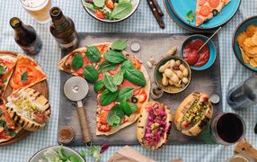 Пицца с хотдогами на столе с соусом