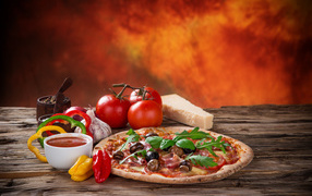 Пицца с колбасой и грибами на столе с соусом и овощами 