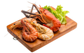 Boiled shrimp with lettuce on a cutting board