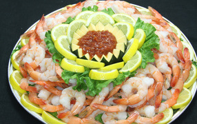 Boiled shrimps with lemon and sauce on a large plate