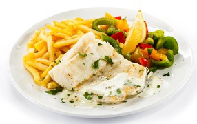 Fish fillet on a plate with potatoes and salad on a white background