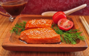 Красная рыба с кунжутом на тарелке с помидорами и укропом