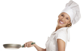 Улыбающаяся девушка повар со сковородкой в руке на белом фоне