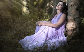 Девушка в красивом платье под деревом 