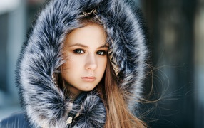 Молодая девушка в меховом капюшоне 