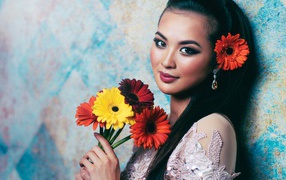 Красивая девушка азиатка с букетом гербер в руках