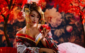 Красивая девушка азиатка в кимоно с цветком в руке