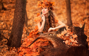 Красивая девушка осень в костюме из желтых листьев 