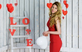 Красивая блондинка в красном платье с шариком