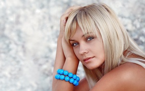 Красивая блондинка с большим голубым браслетом на руке
