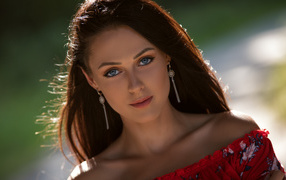 Красивая голубоглазая брюнетка с серьгами у ушах