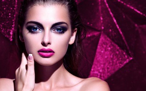 Красивая голубоглазая брюнетка с макияжем на сиреневом фоне