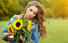 Beautiful brown-haired woman with a bouquet of sunflowers in her hand