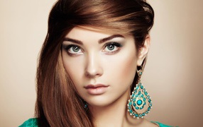 Beautiful brown-haired woman with big earrings with turquoise