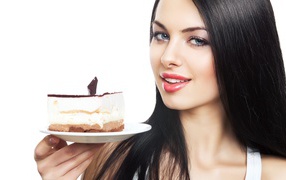 Красивая брюнетка с куском торта на блюдце