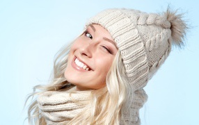 Красивая веселая блондинка в теплой шапке зимой