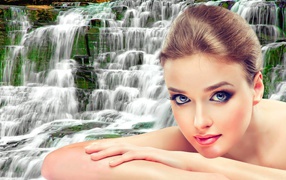 Beautiful gentle girl on a waterfall background