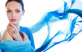 Красивая девушка в голубой накидке на белом фоне